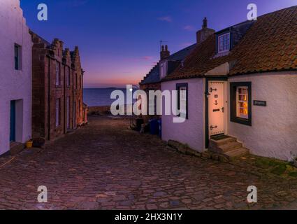 Une vue sur une rue pavée, en direction de l'île de Mai dans la rivière Forth, dans le village de East Neuk de Crail, Fife, Écosse Banque D'Images