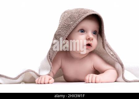 bébé sort de sous une serviette sur un fond blanc isolé Banque D'Images