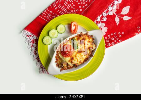 Un plat grec moussaka avec salade dans un plat isolé sur une nappe colorée vue sur le dessus sur fond gris Banque D'Images