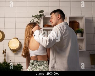 Vue arrière de la cuisine en couple et de regarder les uns les autres avec amour. Atmosphère romantique dans le concept de relation. Photo de haute qualité Banque D'Images