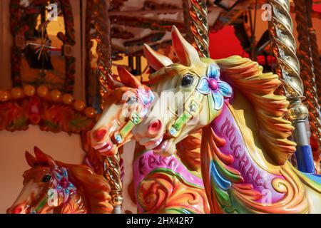 Gros plan d'un cheval aux couleurs vives sur un carrousel à manège Banque D'Images