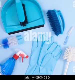 Fond bleu pastel avec outils de nettoyage pour les travaux domestiques. Pose à plat Banque D'Images