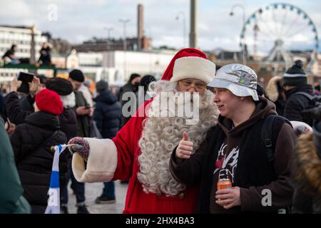 Homme posant avec le Père Noël tout en célébrant la toute première médaille d'or olympique de hockey sur glace en Finlande à Helsinki, en Finlande Banque D'Images