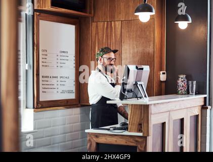 À bientôt. Plan court d'un beau jeune barbier faisant un appel téléphonique à l'intérieur de son barbershop. Banque D'Images