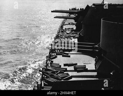 Obus de charrues Pont après bombardement sicilien - des obus vides roulent autour du pont sous les muzzles de refroidissement des gros canons d'un navire de guerre allié après un bombardement naval de Licata, en Sicile, qui a détruit des installations de rivage et protégé le débarquement des troupes alliées. Après que les coques refroidissent, les marins les rembalent pour l'expédition aux usines de munitions où ils sont de nouveau utilisés. 13 septembre 1943. Banque D'Images