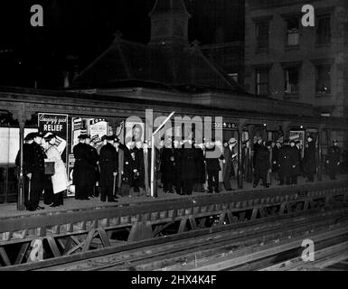 Knell de la 'El' -- peu avant minuit le 4th décembre; le service a cessé sur la 6th avenue 'El'. La structure sur laquelle ont été transportés des millions de passagers sur les cinq miles les plus professionnels du monde est devenue une victime du progrès. La structure existe depuis plus de soixante ans. La police garde sur la plate-forme sud de la gare au 53rd, stand 8th avenue, attendant l'arrivée du dernier train sud. 19 avril 1950. (Photo d'ACME). Banque D'Images