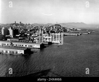 S. F. Le secteur riverain a déserté alors que la grève des navires se poursuit -- une grève des commis est en cours depuis le 10 novembre. Le célèbre Embarcadero de San Francisco -- normalement une scène d'activité animée -- présente une apparence déserte. Les propriétaires, incapables de charger et de décharger leurs navires, de fuir le port, et les jetées sont vides de navires. Cette vue montre des jetées désertes, l'horizon de la ville en arrière-plan. Le bâtiment Ferry est en premier plan au centre. Tour Coit dans le sol arrière. 12 décembre 1939. (Photo de ACME Newsspatures). Banque D'Images