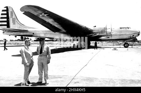 Mettre des touches de finition sur Douglas B-19 -- pour sortie seulement après B-19 vole Santa Monica, en Californie: Lieut. Le colonel James G. Taylor, ici en photo, parle au major Stanley Umstead qui votera pour la première fois le Douglas B-19, le plus grand bombardier expérimental jamais construit pour l'armée américaine, montré en arrière-plan, alors que les préparatifs finaux sont faits pour son premier vol d'essai. L'avion à quatre conducteurs, qui a coûté $3,500,00 à construire, pèse plus de 41 tonnes et a une extension d'aile de 212 pieds. Conformément aux ordres de l'armée, cette photo ne doit pas être publiée tant que le B-19 ne dévolte pas sur son premier bateau d'essai Banque D'Images