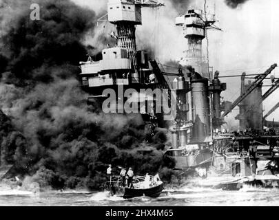 26th janvier 1943. U.S. Navy photo. Spectaculaire des scènes photographiques des horreurs de Pearl Harbor viennent de recevoir des États-Unis Un petit bateau sauve les marins des 31 800 tonnes U.S.S. La Virginie occidentale brûlait au premier plan. Le déploiement de fumée au milieu des navires montre où les dommages les plus importants se sont produits. Notez les deux hommes dans la superstructure. Le Tennessee suivant est en intérieur. 26 janvier 1943. Banque D'Images