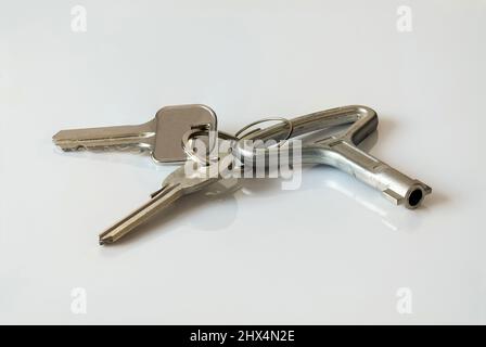 Clés d'un appartement, maison sur un anneau en métal, sur fond blanc, divers types de clés Banque D'Images