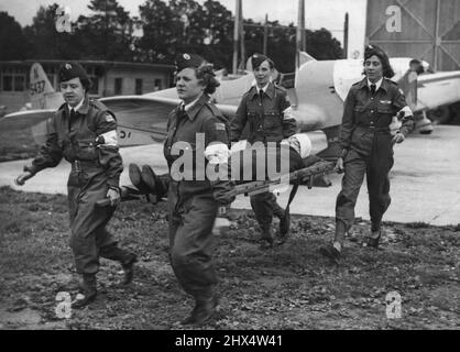 Démonstration des filles de la Garde aérienne civile - premiers secours membres de la Garde aérienne civile transportant la « victime » d'un accident de vol, au large de l'aérodrome de Plymouth, sur une civière. La section de 'la Garde aérienne civile qui est stationnée à l'aérodrome de Plymouth, a une section d'ambulance de femme. Ces filles ont appris les premiers soins d'une infirmière qualifiée et apprennent tout particulièrement comment faire face aux personnes blessées dans des accidents de vol. 26 juillet 1939. (Photo de Keystone). Banque D'Images