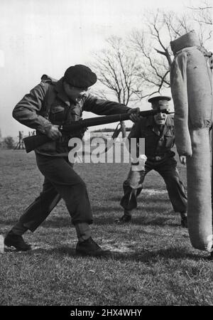 Soldats en formation -- stimulés par son instructeur Q.M.S.I. Mackenzie, l'un des instructeurs principaux de l'École, le Pte. Brian Hulbert de Chippenham (Wilts), est vu engagé dans la pratique de la baïonnette pendant l'entraînement dans la petite aile des armes de l'École d'infanterie, Hythe (Kent). L'aile des armes légères de l'École d'infanterie de Hythe (Kent) est un développement de l'ancienne École de mousquetry. Son objectif principal est la formation de N.C.O.'S et de Privats, réguliers et militaires nationaux, pour un cours intensif dans la manipulation de toutes les armes, qu'un fantassin moderne peut appeler Banque D'Images