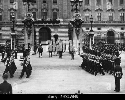 Trooping la couleur. Une magnifique exposition militaire qui attire des milliers. La célébration officielle de l'anniversaire du Roi s'est poursuivie le 4th juin, lorsque H.M. le roi et d'autres membres de la famille royale ont assisté à la spectaculaire cérémonie de trooping la couleur effectuée par les gardes sur la parade des gardes à cheval. 430306. H.M. le roi prend le salut de ses gardes alors qu'ils marchent au-delà de Buckingham place. H.M. la Reine et d'autres membres de la famille royale peuvent être vus le balcon. 19 juillet 1932. (Photo de Sport & General Press Agency, Limited). Banque D'Images
