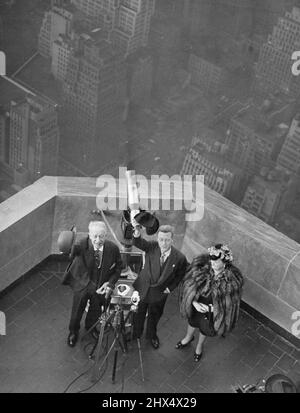 Au-dessus des trottoirs de New York -- Le duc de Windsor (au centre) fait vagues son chapeau tout en étant montré le bâtiment de l'état de l'empire et sa vue de New York le 21 octobre par l'ancien gouverneur Alfred E. Smith et sa femme, c'est un télescope derrière eux comme ils se tiennent sur une plate-forme d'observation près de la partie supérieure de l'édifice. 21 octobre 1941. (Photo par photo de presse associée). Banque D'Images
