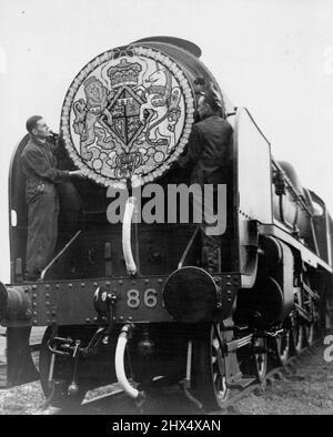 La lune de miel spéciale -- les ouvriers ont mis la touche finale à la plaque avec des armoiries sur le Lord Anson à Waterloo à jour (mardi). Les derniers préparatifs sont bing fait sur le train spécial à cinq autocars qui sera utilisé par S.A.R. la princesse Elizabeth et Lieut. Philip Mountbatten, jeudi pour la première partie de leur voyage à Broadlands a Romsey, où une partie de la lune de miel doit être passée. La voiture Pullman Rosemary dans laquelle ils voyageront se convertira pour l'occasion en un Bower de fleurs, et le train sera tiré par le moteur lord Anson décoré d'une grande tête de lit C Banque D'Images