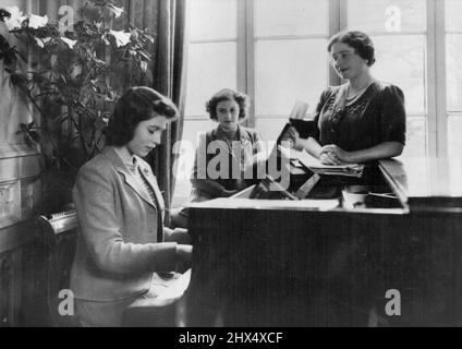 Cherchant à se détendre de leurs difficiles devoirs de guerre. La princesse Elizabeth au piano, divertit sa mère et sa sœur plus jeune. Leurs Majestés, le Roi et la Reine, et leurs enfants à la maison 'quelque part dans le pays', montrent leur grande musique intéressée. Les deux Princesses, la princesse Elizabeth et la princesse Margaret Rose, comme leur mère, sont toutes deux des pianistes accomplis. 1 janvier 1943. (Photo de Fox photos). Banque D'Images