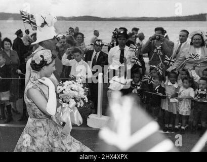 La Reine aux Bermudes -- la Reine marche avec le lieutenant-général du gouverneur des Bermudes Sir Alexander Hood à travers une file d'enfants applaudissent peu après avoir quitté son avion à son arrivée au terrain de gentiment, Bermudes, novembre 24. Sa Majesté a passé une journée sur l'île avant de prendre un vol en Jamaïque. Dans le chemin de toutes les femmes, la Reine vérifie sur le détail sur la course - l'ensemble de son collier, les boucles sur son cou, l'inclinaison de son chapeau. 26 novembre 1953. (Photo par photo de presse associée). Banque D'Images