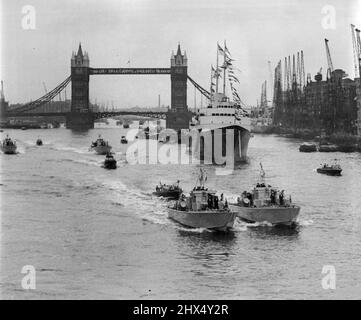 'Britannia' in the Pool - Queen and Duke are Home - des spectateurs sur des bateaux fluviaux surpeuplés applaudissent le yacht royal Britannia lorsqu'elle entre dans la piscine de Londres jusqu'à aujourd'hui (samedi), ramenant la Reine et le duc d'Édimbourg au cœur de la capitale après leur excursion de 50 000 kilomètres dans le Commonwealth. Le yacht royal avait traversé Tower Bridge (arrière-plan) sur le chemin de son berth, Battle Bridge Tier dans la piscine. 15 mai 1954. (Photo de Reuterphoto). Banque D'Images