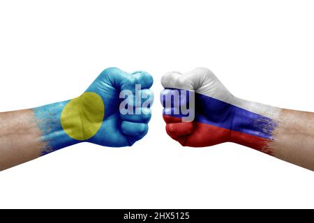 Deux mains poinçonner l'une à l'autre sur fond blanc. Les drapeaux de pays ont peint des poings, le concept de crise de conflit entre les palaos et la russie Banque D'Images