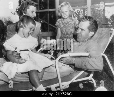 Nixon se détend avec la famille - le sénateur Richard Nixon, le candidat républicain à la vice-présidence, se détend avec sa famille aujourd'hui sur le gazon de leur Washington Home après une semaine éprouvante de campagne au cours de laquelle il s'est mis en l'air pour expliquer ses finances personnelles. Le sénateur est accompagné de Mme Nixon, leurs enfants, Julie (à gauche), 4 ans, et Patricia, 6, et leur célèbre épagneul cocker 'Dames.' 28 septembre 1952. (Photo par AP Wirephoto). Banque D'Images