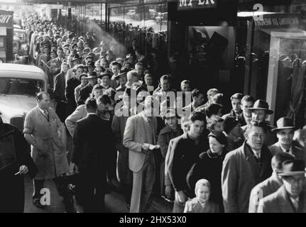 Des milliers de personnes se sont déversées dans l'Emporium Myer au jour le jour où la réservation a été ouverte pour les Jeux Olympiques de 1956. Une file d'attente de trois profondeurs (ci-dessus) s'étendait d'une entrée spéciale au magasin de la rue Lonsdale sur plus de 100 mètres le long de la rue jusqu'au coin de la rue Swanston. Plusieurs personnes avaient attendu à l'extérieur du magasin pendant la nuit. La réservation, qui a ouvert ses portes à 9 h, a commencé simultanément à Sydney, Adélaïde, Perth et Melbourne. 18 mai 1955. Banque D'Images