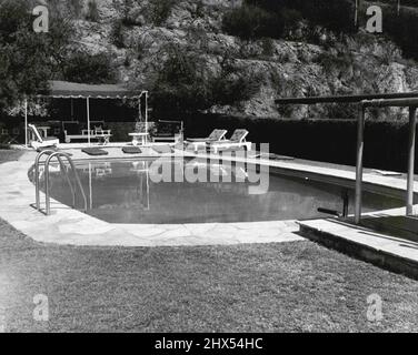 The Reagans at Home -- la grande piscine avec son plongeoir de hauteur moyenne et son patio ombragé est l'une des caractéristiques de la maison de Jane Wyman et Ronald Reagan. Les stars Warner Bros. Apparaissent actuellement dans 'Cheyenne' et 'Tallion Road' respectivement. 19 novembre 1952. (Photo de Floyd McCarty, Warner Bros.). Banque D'Images