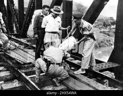 Frontières - in ***** . Deux constables si la police de Hong Kong examine des colis de biens personnels appartenant à des Chinois sur leur chemin de l'autre côté de la frontière vers le territoire britannique. Sur le pont ferroviaire de Lou, qui marque la frontière entre les territoires chinois et britannique, les Chinois qui se rendent dans la zone britannique ont leurs paquets recherchés pour les armes légères par deux gendarmes chinois de la police de Hong Kong, dans cette photo reçue de Hong Kong. 27 octobre 1949. (Photo de Reuterphoto). Banque D'Images