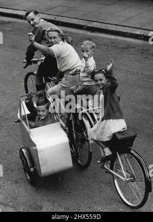 Un 'Carriage' pour cinq M. Eric Jewell de Finchley, Londres, a été fatigué de faire la queue pour des bus avec des enfants fatigués, donc avec sa femme, il est retourné à son hobby de vélo. Il a construit un sidecar et a ajouté à son tandem - vélo. Mais ce n'était pas suffisant pour tenir toute la famille, donc la moitié d'un vélo a été mis sur pied derrière et une selle supplémentaire et une paire d'aiglebars placés derrière la mère - maintenant il a un quinticycle fait pour cinq et la famille sont tous heureux pendant qu'ils voyagent ensemble. 08 août 1950. (Photo de Paul Popper Ltd.). Banque D'Images