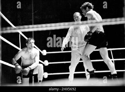 Freddie Miles bat Gus Lesnevitch pour gagner le titre mondial -- Lesnevitch, qui a été mal coupé dans le neuvième tour. Teddy Waltham, l'arbitre vu au centre. Freddie Mills (Gt. Britain) a battu Gus Lesnevitch (É.-U.) dans leur concours pour le championnat du monde de poids lourds légers, à la ville blanche, Londres. Mille a gagné sur les points. 27 juin 1948. Banque D'Images