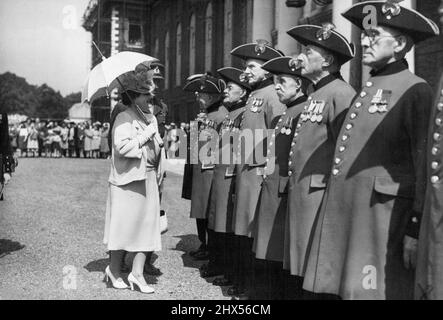 La Reine assiste à l'Assemblée des travailleurs bénévoles -- la Reine, portant un parasol pour la protéger du soleil, inspectant les pensionnés de Chelsea à l'Hôpital Royal de Chelsea, cet après-midi (mercredi). Cette après-midi, sa Majesté la Reine a assisté à une assemblée des travailleurs bénévoles des marins soldats incorporés et de la Airman's Help Society à l'hôpital Royal, Chelsea, Londres. 11 juillet 1946. (Photo de Reuterphotos) Banque D'Images