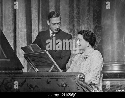 Leurs Majestés le roi George VI et la reine Elizabeth Royal Silver Wedding photo -- Une charmante étude du roi et de la reine prise dans la salle bleue au premier étage de Buckingham Palace. La Reine joue la célèbre chanson intitulée « The Toast ». 20 avril 1948. (Photo de Baron, Cmera Press) Banque D'Images