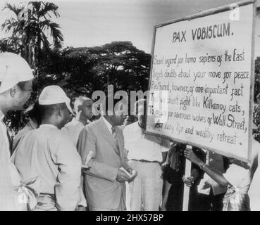 L'UNixon parle avec des manifestants anti-américains -- le vice-président Richard M. Nixon, au centre, regarde le panneau anti-américain tenu par des manifestants de gauche à Pegu, Birmanie, à 40 miles au nord-ouest de Rangoon, le 26 novembre. Nixon, traversant la ville antique lors de sa tournée mondiale, insistait pour se promener parmi les manifestants et discuter avec eux. Sa discussion avec le chef du rassemblement a été amicale et il a été secoué de main tout autour lorsque Nixon est parti. 05 décembre 1953. (Photo par AP Wirephoto). Banque D'Images