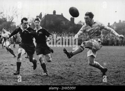 Rugby: Université de Cambridge V Steele Bodger XV -- Une belle image d'action comme J. Roberts Cambridge U) fait un coup de volant en contact avec F. Sykes et R. Willis (Steele-Bodger's XV) course à intercepter. L'université de Cambridge a battu le XV de M.R. Steele-Bodger dans leur match de rugby annuel joué à Cambridge. 25 novembre 1954. (Photo de Sport & General Press Agency, Limited). Banque D'Images