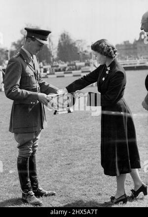 La Reine présente le trophée à la garde au Badminton -- HM la Reine photographiée hier, vendredi, présentant le trophée au capitaine H.A.Q. Darley, de la Royal Horse Guards, vainqueur de l'épreuve équestre de trois jours au Badminton. La Reine, le duc d'Édimbourg et la princesse Margaret, actuellement en séjour à Badminton House, Glos., en tant qu'invités du duc de Beaufort, ont été des spectateurs aux essais olympiques de la British Horse Society ont tenu i le terrain de leur hôte pendant les trois derniers jours. 26 avril 1952. (Photo de Fox photos). Banque D'Images