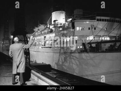 Les voiles « gothiques » pour la Jamaïque -- une personne non identifiée se déonde du quai tandis que le bateau de visite royal « gothic » s'éloigne du quai du roi George V, pour descendre la Tamise sur la marée de ce soir, le 10th novembre. Pendant deux heures dans l'après-midi, M. Basil Sanderson, président de la Shaw Savill Line, l'a inspectée. Enfin, il a convenu qu'elle était prête pour la tournée. Le paquebot était sur le chemin de la Jamaïque, où la Reine et le duc d'Édimbourg se joindront à elle le 27th novembre. 11 novembre 1953. (Photo par photo de presse associée). Banque D'Images
