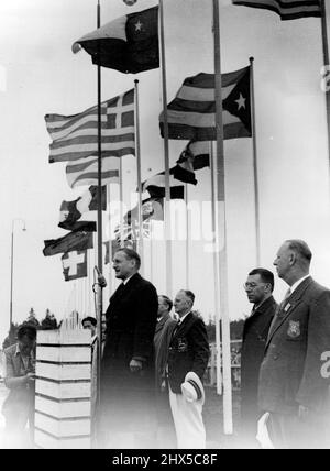 Lord Burghley à la cérémonie olympique de levée de drapeau -- Lord Burghley, représentant le Comité international olympique, s'adressant aux concurrents lorsque le Jack syndical et les drapeaux d'autres nations en compétition ont été histés dans le village olympique de Kappyla, les autres drapeaux soulevés lors de cette cérémonie étaient ceux de l'Italie, de l'Égypte, de l'Afrique du Sud, de la Nouvelle-Zélande, de la Birmanie, Suisse, Hollande, ia et Singapour. 16 juillet 1952. Banque D'Images