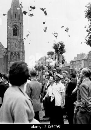 Comme les avis ont été affichés deux hommes dans la foule ont jeté ces journaux déchirés (vu ici) dans le SIR et a crié «un autre meurtre». Ruth Ellis a été pendue aujourd'hui à la prison de Holloway pour le meurtre de son amant de 25 ans, David Blakely. Des centaines de personnes attendaient devant la prison. Trois policiers montés et une police de quinze pieds avec des armes reliées gardaient l'entrée de la prison tandis que d'autres policiers bordaient Parkhurst-Road pour garder en arrière les foules déconnectées. 13 juillet 1955. (Photo par Daily Mirror). Banque D'Images