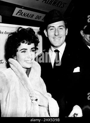 Elizabeth Taylor ici pour se marier Michael Wilding, 20 ans son Senior -- le couple à l'aéroport de Londres après l'arrivée d'Elizabeth Taylor tard dans la nuit dernière. Elizabeth porte l'anneau de fiançailles qu'elle a dû s'acheter parce que Wilding n'avait pas de dollars. Mais elle lui a acheté un "petit anneau de mariage anglais", a déclaré Wilding hier soir. Il est en platine. Elizabeth Taylor, une star de cinéma anglaise de 19 ans, née en Angleterre mais travaillant à Hollywood, est arrivée hier soir à l'aéroport de Londres après deux heures de retard par les tempêtes. 20 février 1952. (Photo de Paul Popper) Banque D'Images