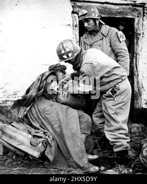 Les Yanks traitent les blessés du parachutiste allemand les soldats américains traitent la blessure d'un parachutiste allemand lors de la course de Yank pour soulager les troupes américaines piégées à Bastogne par la percée allemande de décembre en Belgique et au Luxembourg. 6 janvier 1945. (Photo par photo de presse associée). Banque D'Images