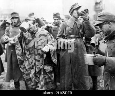 Les prisonniers allemands se sont mis en prison les prisonniers allemands ragurent leur nourriture peu après leur arrivée dans un camp américain de prisonniers de guerre près du front. Du jour J, 6 juin 1944; jusqu'en novembre 30, les armées alliées ont capturé 750 000 troupes nazies sur le front occidental. 26 février 1945. (Photo par U.S. signal corps photo). Banque D'Images