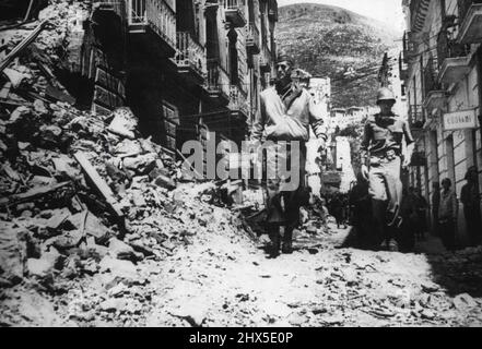 Le général Clark sur le champ de bataille italien photo montre:- le général Mark Clark, commandant de la Cinquième armée, marche à travers une rue remplie de gravats qui a été le théâtre de combats lourds pendant la bataille pour un village entre Formuia et Itri, sur l'autoroute 7, en Italie. 31 mai 1944. Banque D'Images