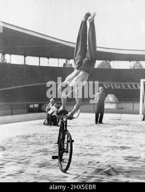 Se déplacer par cycles - « regarde, ma, pas de pieds ! » Le cycliste yougoslave Stanislav Vakulic fait une variante de la routine du no Hands lors des derniers championnats du monde de cyclisme qui se sont tenus près de Rome. Il travaille à un bon rythme, puis se tient sur le guidon et se repose sur ses mains. 23 septembre 1955. (Photo de United Press). Banque D'Images