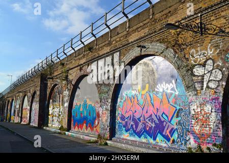 Graffitis sur les anciennes arches de chemin de fer de Deptford Creek, Greenwich, photographiés à la lumière de l'hiver. Le viaduc London Bridge-Greenwich a été réalisé en 1836 Banque D'Images