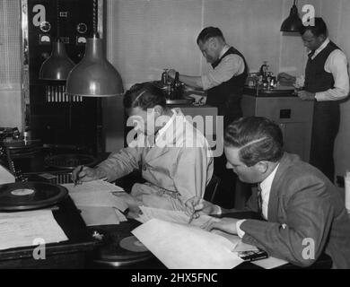 Enfin, l'enregistrement de l'épisode est coupé. Neville Merchant (L) production Panel Operator met dans la musique et les effets sonores accessoires tandis que le producteur Jacklin suit le dialogue sur le script. En arrière-plan, les machines de coupe sont en cours d'enregistrement. En arrière à gauche, Bill Dukes, technicien, coupe le record d'acétate tandis que l'ingénieur Burt Munings coupe le record de processus. 4 novembre 1944. Banque D'Images