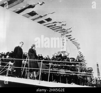 Tous les mains sur le pont pour les couples royaux -- les drapeaux en continu forment une arche colorée au-dessus de la princesse Elizabeth et du duc d'Édimbourg lorsqu'ils débarquent du croiseur Ontario à Sydney, en Nouvelle-Écosse, hier. Les membres de l'équipage du navire, qui transportait le couple royal de l'Île-du-Prince-Édouard, Jam les ponts et les tourelles d'armes à feu pour obtenir une meilleure vue de leurs passagers célèbres. L'Ontario transportera le couple à New ­foundland lors de la dernière étape de leur tournée nord-américaine de 15 000 milles. 11 novembre 1951. (Photo par AP Wirephoto). Banque D'Images