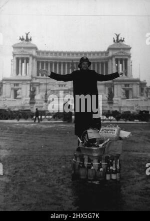 Lorsque le lot du policier est heureux, Un policier en service à l'une des principales intersections de Rome, où Coroso Umberto se trouve sur la Piazza Venezia, se trouve sur sa plateforme de circulation entourée de cadeaux le 6 janvier le jour de la journée traditionnelle de don de Befana en Italie. La plupart de ses présents semblent être sous forme liquide. Notez le monument Vittorio Emmanuele en arrière-plan. 16 janvier 1947. (Photo par photo de presse associée). Banque D'Images