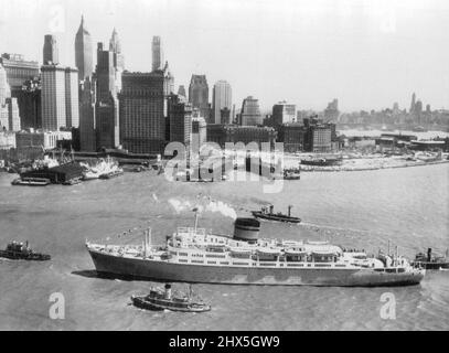 Comme Un bateau peint sur Un océan peint -- c'est une journée claire et lumineuse alors que l'Ocean Monarch passe lentement devant les gratte-ciel du centre-ville de New York pour la première fois pour jeter l'ancre sur un quai de North River aujourd'hui après un voyage de 10 jours au départ de Londres. Le navire de 14 000 tonnes, conçu pour le service de croisière, mesure 516 pieds de long et peut transporter 440 passagers. 27 avril 1951. (Photo par AP Wirephoto). Banque D'Images