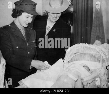 Princesse Elizabeth admire bébé la princesse Elizabeth admire un bébé berceau, montré par Mme Water Elliot, lors d'une visite à la National Association of Girl Guides à Londres où elle a reçu des cadeaux de vêtements de la Nouvelle-Galles du Sud, Australie, mai 29. Les vêtements ont été remis à l'hôpital Queen Charlotte et à l'hôpital Queen Elizabeth. 6 mars 1945. (Photo par photo de presse associée). Banque D'Images