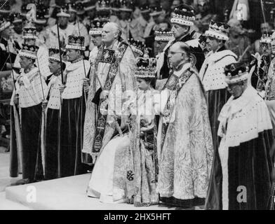 Reine - de la Justice et de la Miséricorde -- La Reine, assise sur le trône et portant la couronne de Saint-Édouard, tient le Scepter royal, l'enseigne du pouvoir et de la justice, et le bâton avec le Dove, la tige de l'équité et de la miséricorde, alors qu'elle se prépare à recevoir l'hommage après le couronnement à l'abbaye de Westminster, à Londres, à ce jour. Les couronnets de pairs et de péeresses font un arrière-plan splendide de la scène. 02 juin 1953. (Photo de Reuterphoto) Banque D'Images