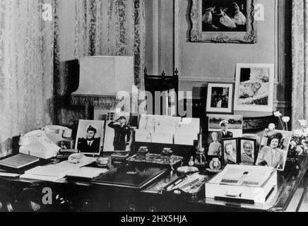 Clarence House - Princess Elizabeth's London Home -- le bureau de la princesse Elizabeth dans son salon à Clarence House, la résidence londonienne de la princesse et du duc d'Édimbourg. Le bureau est de la période Chippendale. Les photographies sont de la reine, de la reine Mary, de la princesse Margaret et de plusieurs du duc d'Édimbourg, dont une prise pendant la guerre quand il portait une barbe. Au-delà, on trouve des photos prises au baptême du Prince Charles, et un tableau du ballet le IAC des Cygnes, d'Oliver Messel. 28 octobre 1949. Banque D'Images